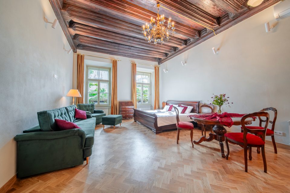 Apartament z łóżkiem typu king-size i zieloną sofą