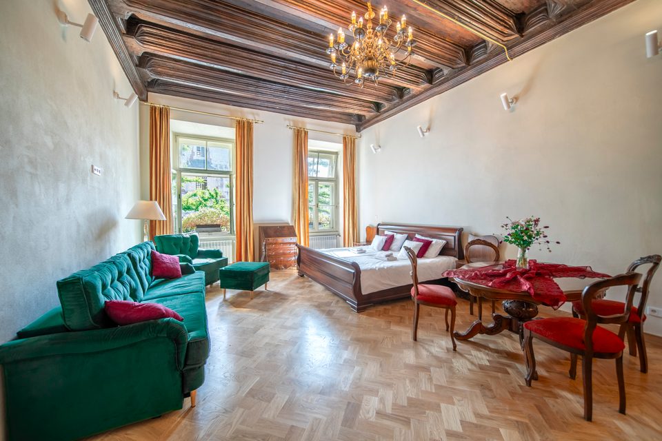 Apartament z zieloną sofą i widokiem na Rynek